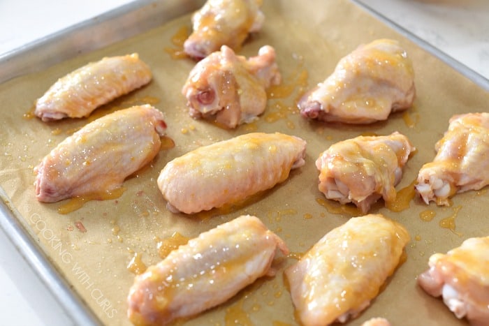 Place the wings on a parchment paper lined baking sheet and brush with the sauce cookingwithcurls.com
