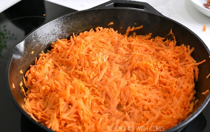 Shredded carrots cooking in the cast iron skillet cookingwithcurls.com