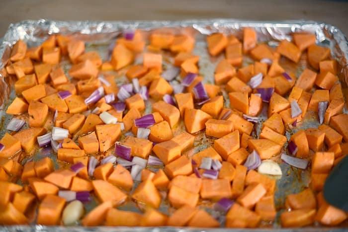 Toss the sweet potato wedges, chopped onions and garlic cloves with oil on a large baking sheet cookingwithcurls.com