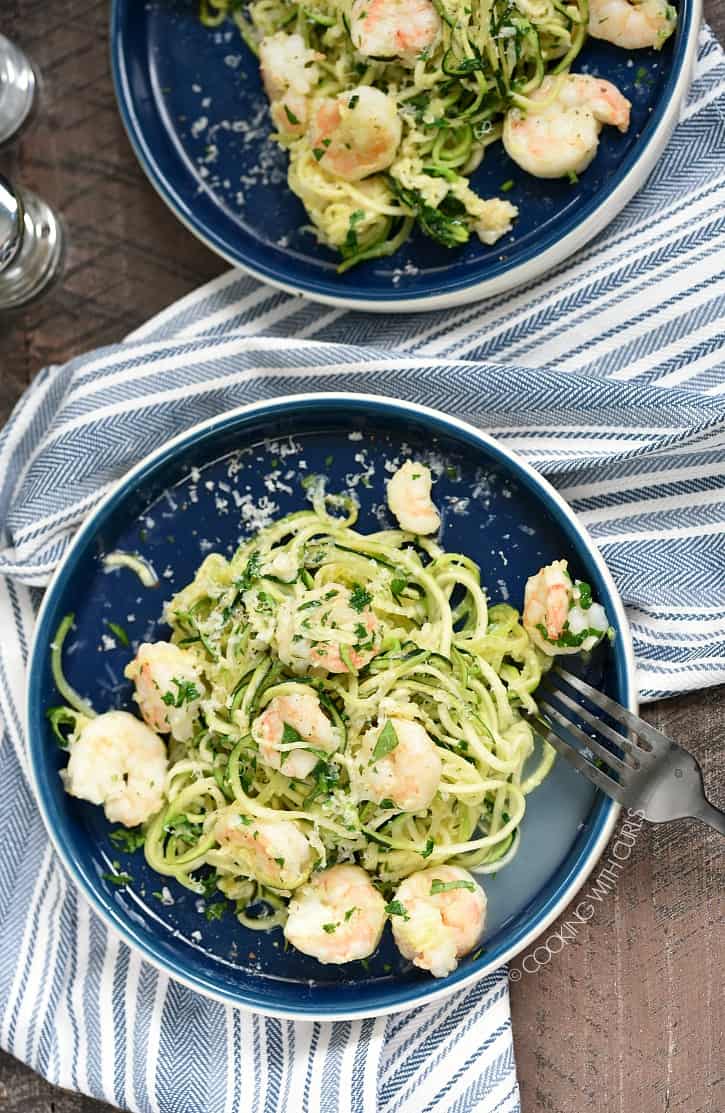 Looking down on two dinner plates with zucchini noodles and shrimp in a butter sauce.
