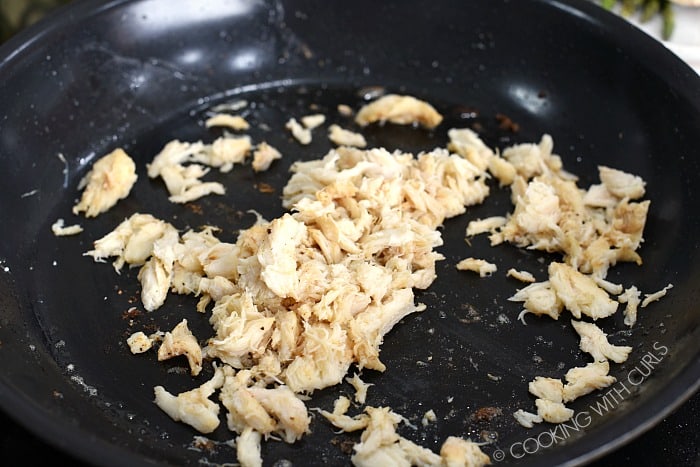 lump crab meat being heated in a non-stick skillet .