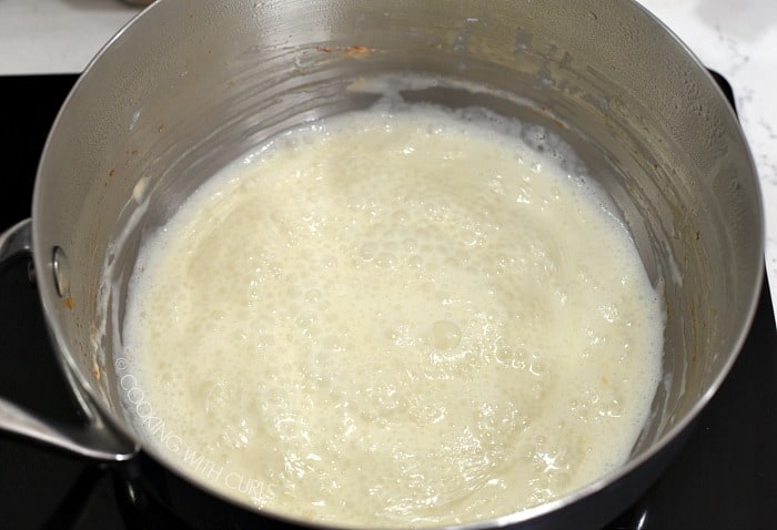 heavy cream simmering in a saucepan