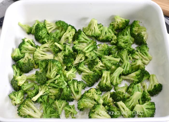 steamed broccoli pieces in a white baking dish