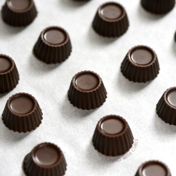 small dark mint chocolate fat bombs lined up on a piece of white parchment paper