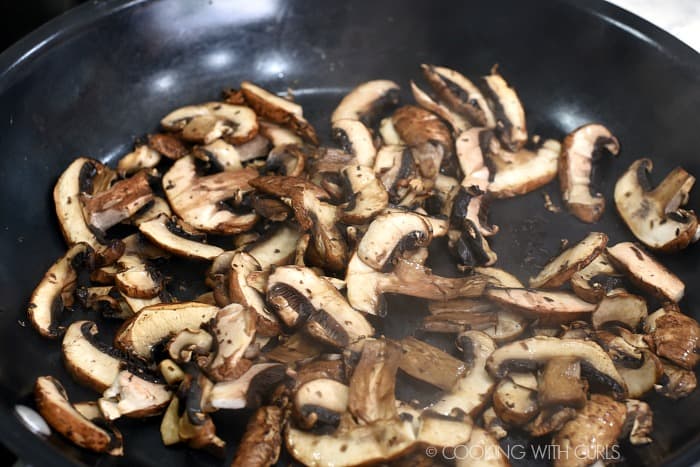 Sliced mushrooms cooked down in a non-stick skillet. 