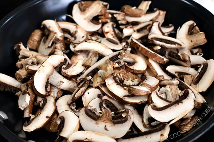 Sliced mushrooms in a non-stick skillet. 