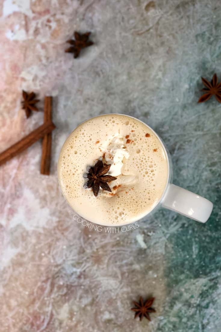 Overhead shot of a Pumpkin Spice Latte surrounded by cinnamon sticks and star anise