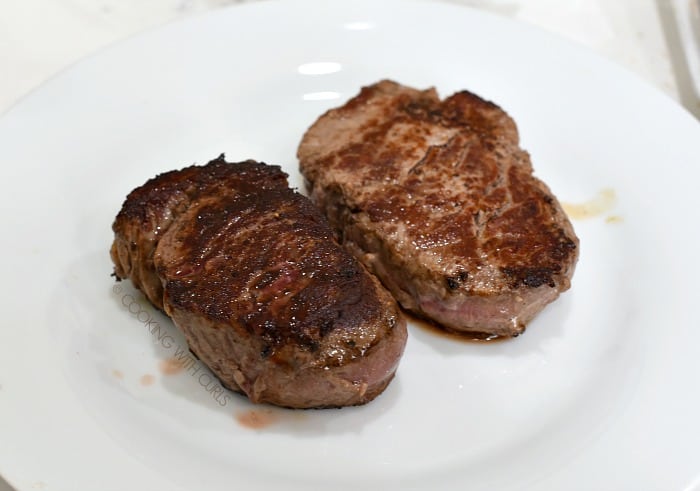 Two medium-rate steaks on a white plate 