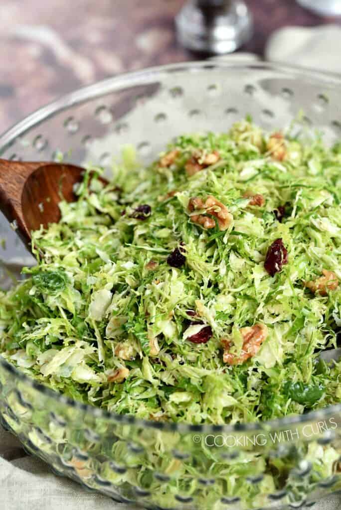 Shaved Brussels Sprouts Salad in a clear, glass serving bowl