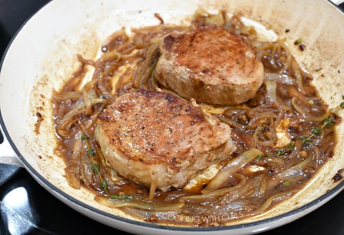 Return the pork chops to the caramelized onion gravy in the cast iron skillet. 
