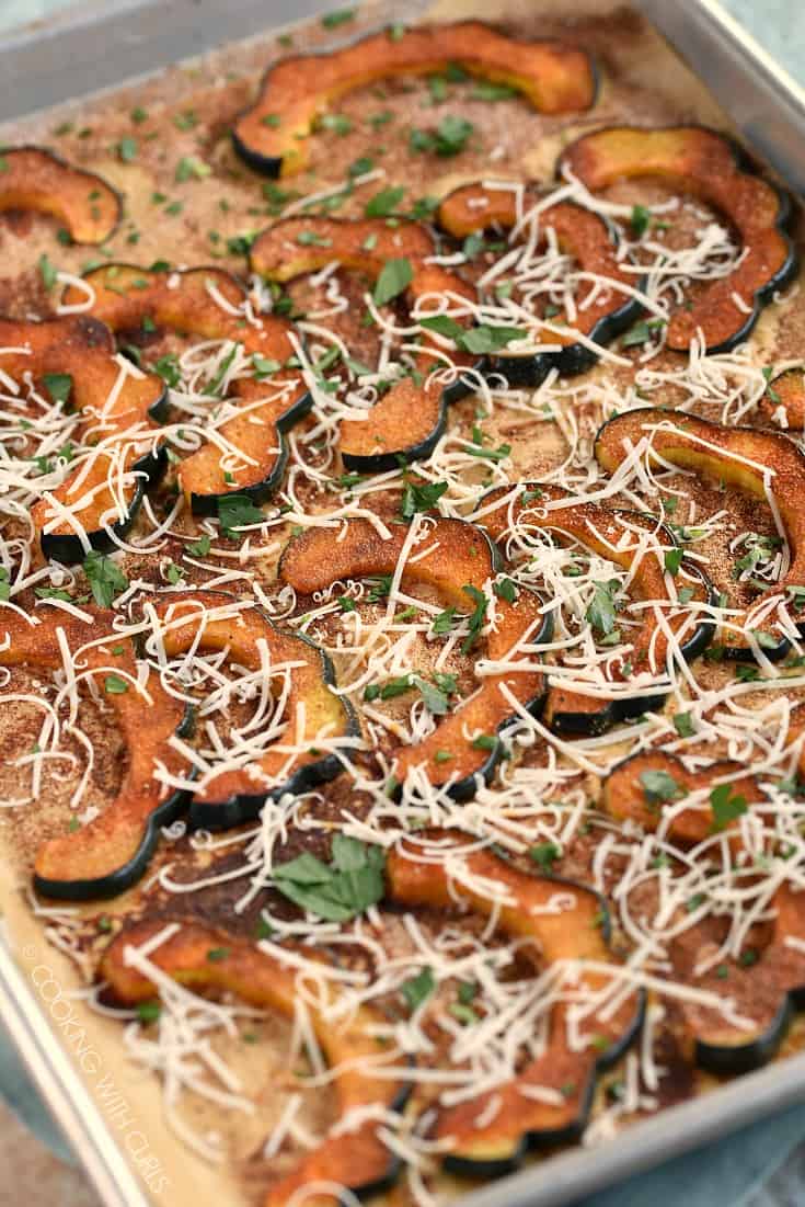 Roasted Acorn Squash slices on a parchment lined baking sheet