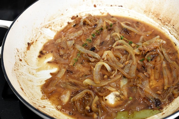 The caramelized onions added back to the skillet with the beef stock and herbs 