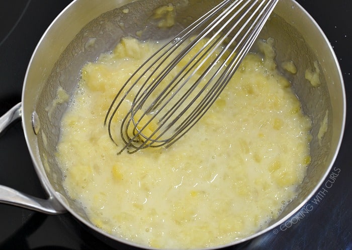Crushed pineapple, cornstarch and sugar with a whisk in a saucepan 