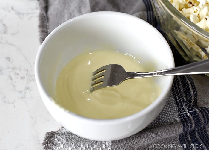 Melted white chocolate and coconut oil in a white bowl 