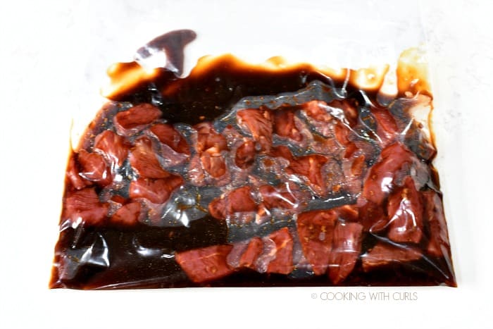 Steak tips marinating in Korean BBQ marinade in a large zipper top bag.
