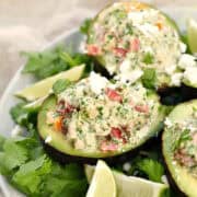 Avocado halves stuffed with tuna, diced bell pepper, and crumbled cheese.