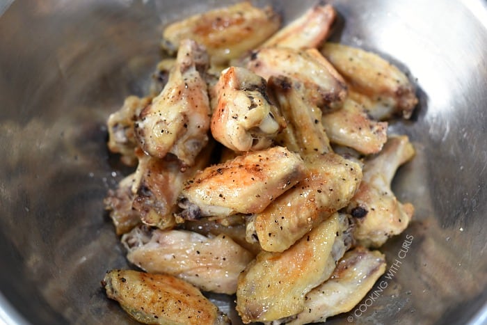 Baked chicken wings in a stainless steel bowl. 