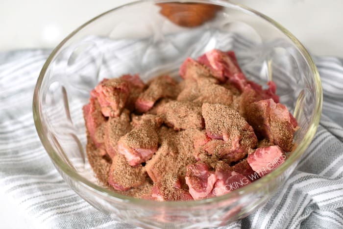 Beef chunks tossed with cafe mocha rub in a large glass bowl.
