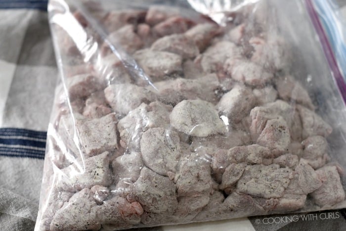 Beef chunks tossed in a plastic bag with seasoned flour. 