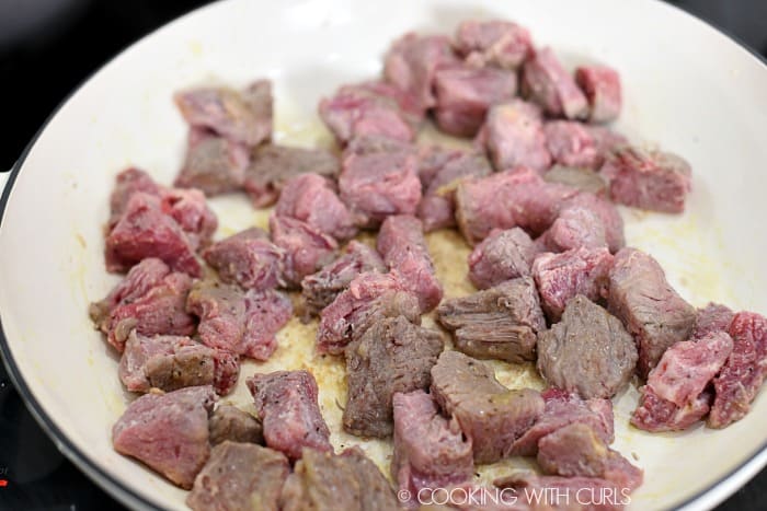 Browned beef chunks in a large casserole pan. 