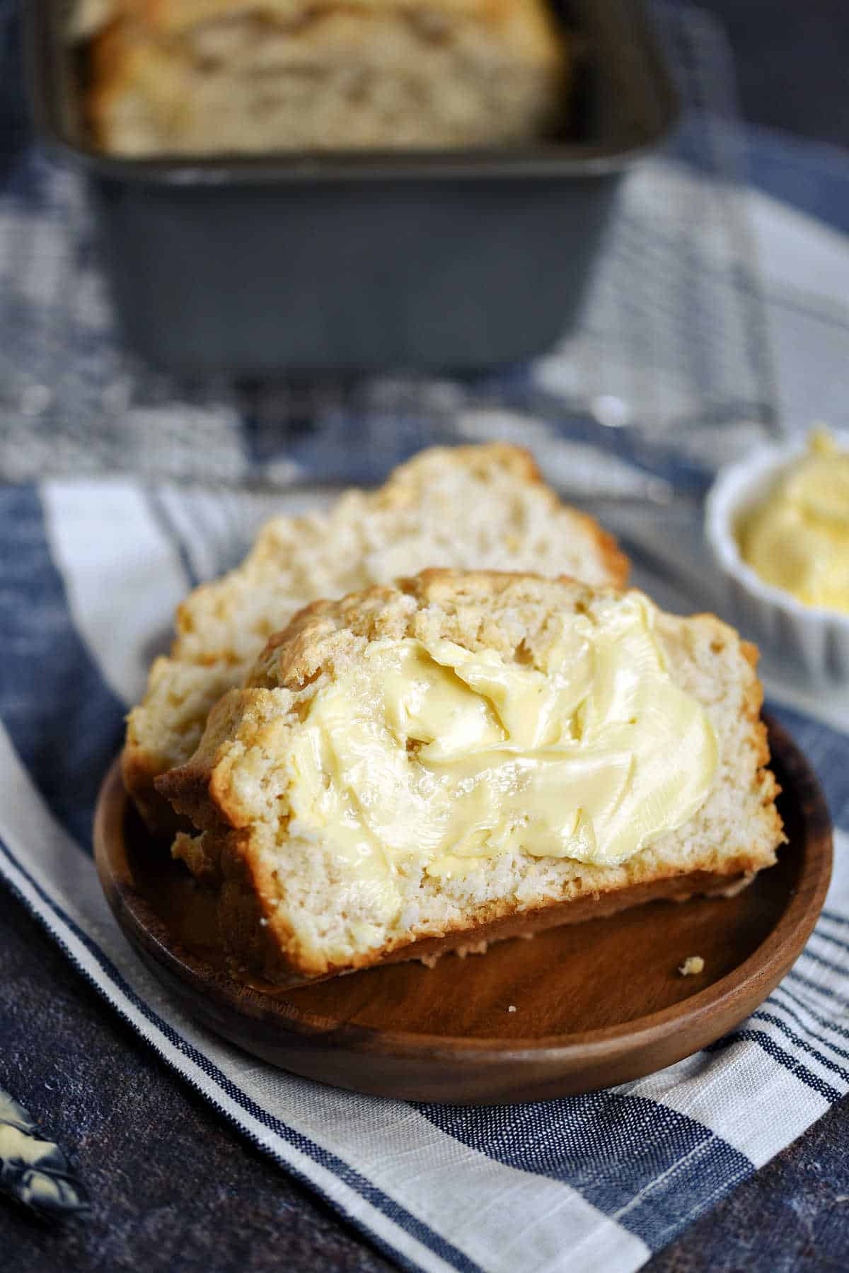 Two buttered slices of beer bread on a plate.