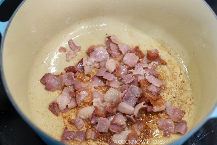 Cooked bacon chunks in a large pan. 