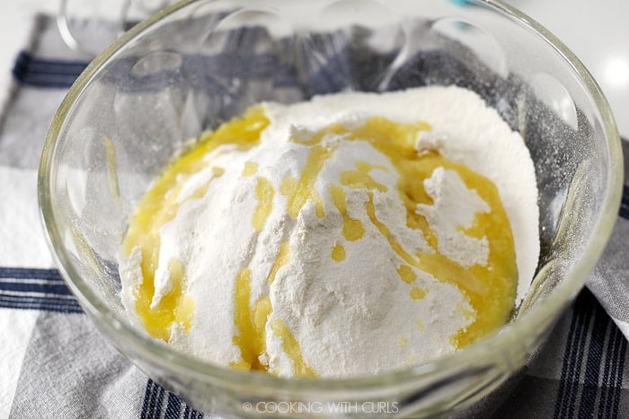 Melted butter added to the flour mixture in a large glass bowl. 