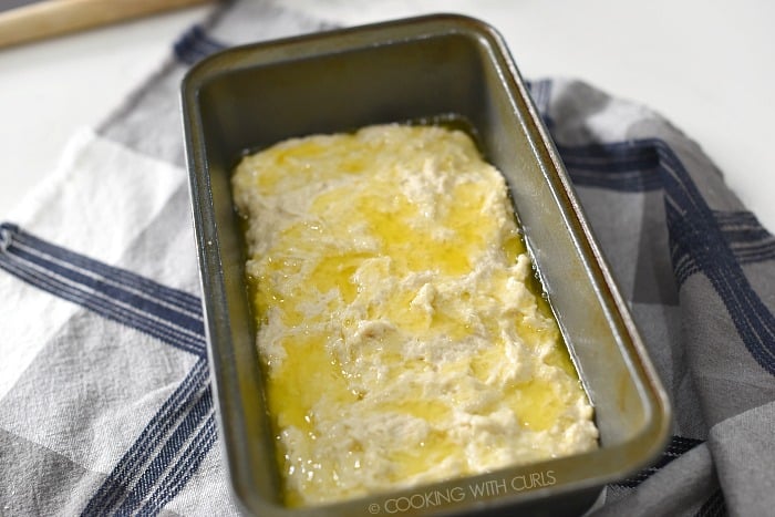 Melted butter poured over the top of the bread batter in a loaf pan. 