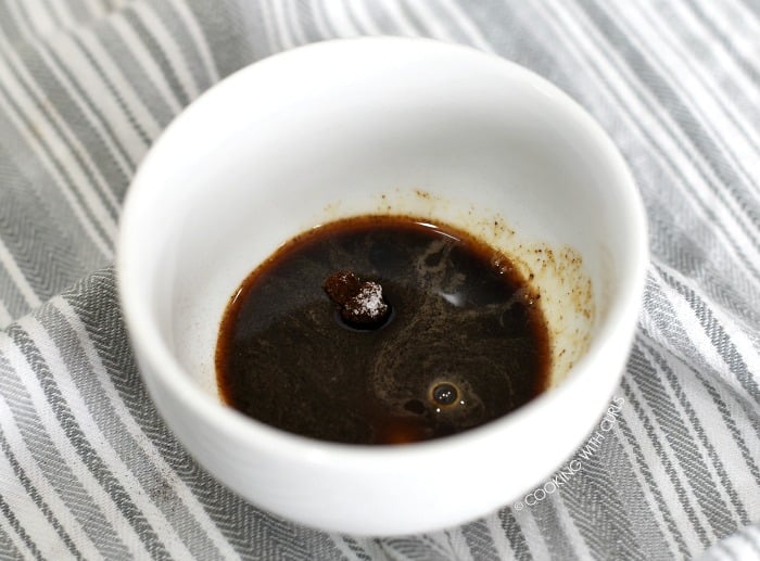 Water, coffee granules and sugar in a small, deep bowl. 