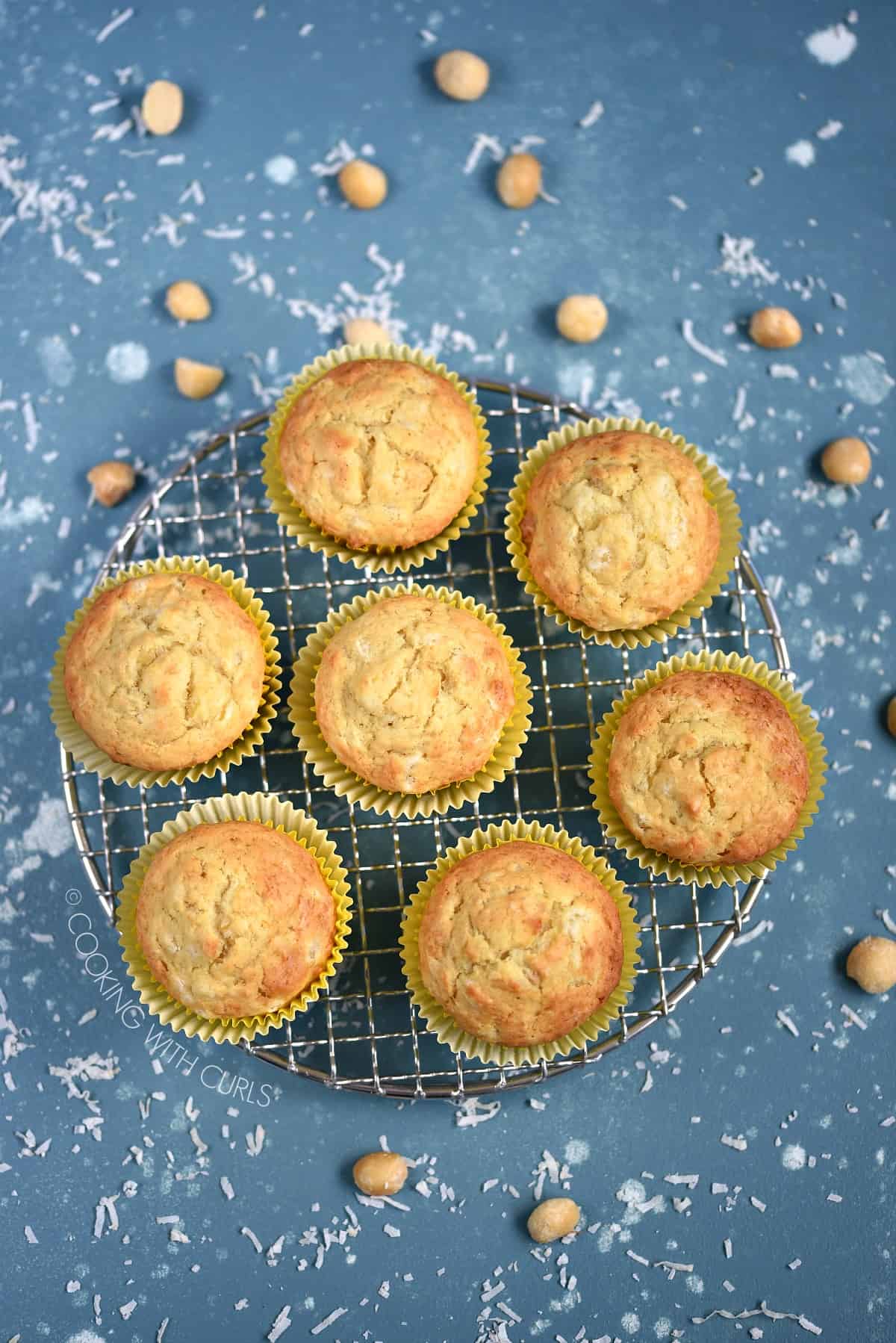 Looking down on seven Pina Colada Muffins on a wire cooling rack.