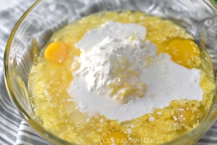 Rum, eggs, oil and coconut cream on top of the cake mix in a large glass bowl. 