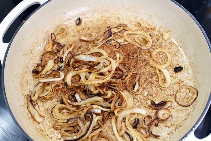 Caramelized onions in a white cast iron skillet.