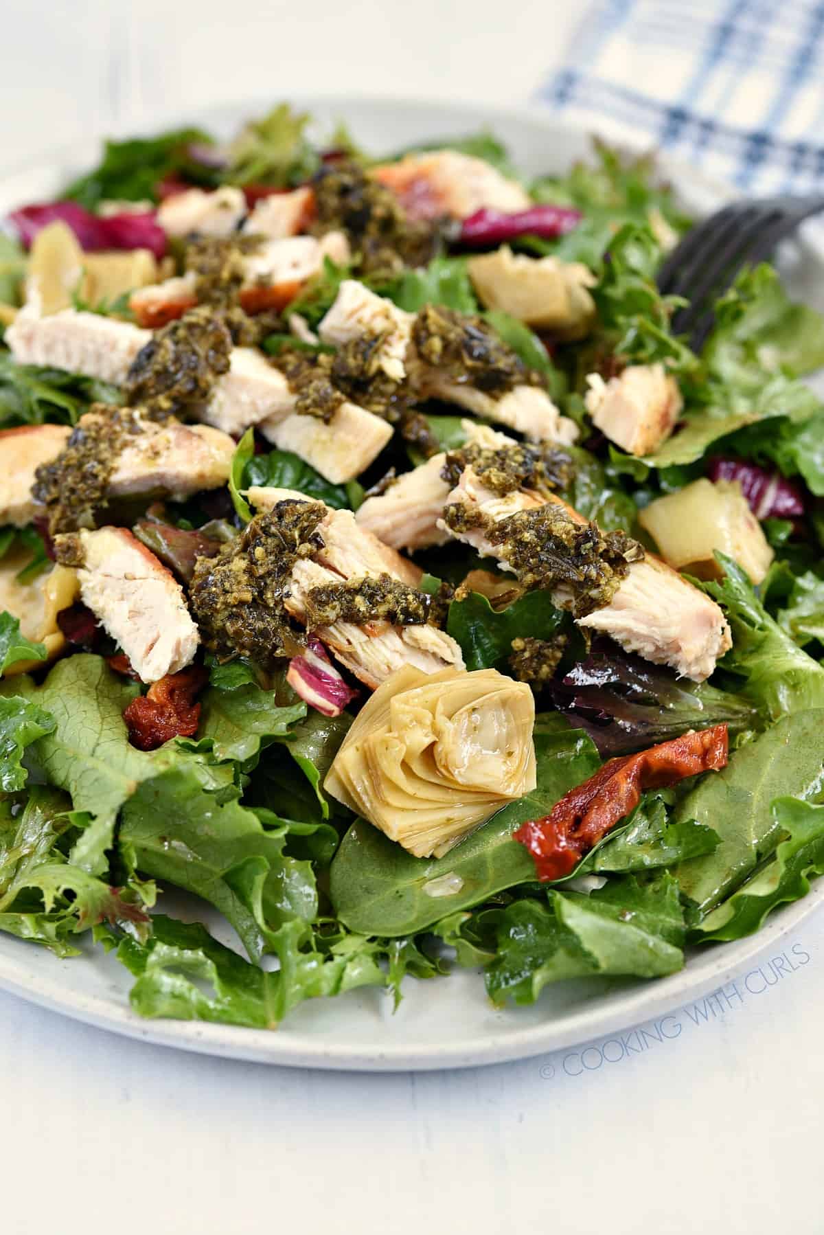 A close-up view of Pesto Chicken Salad on a large white plate.