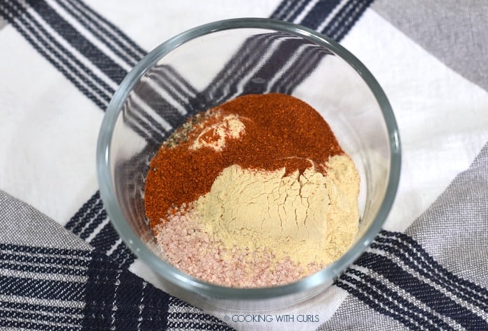 Ground pepper, pink sea salt, garlic powder, cayenne and paprika in a small glass bowl. 