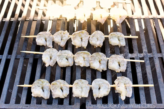 Raw skewered shrimp on the grill. 