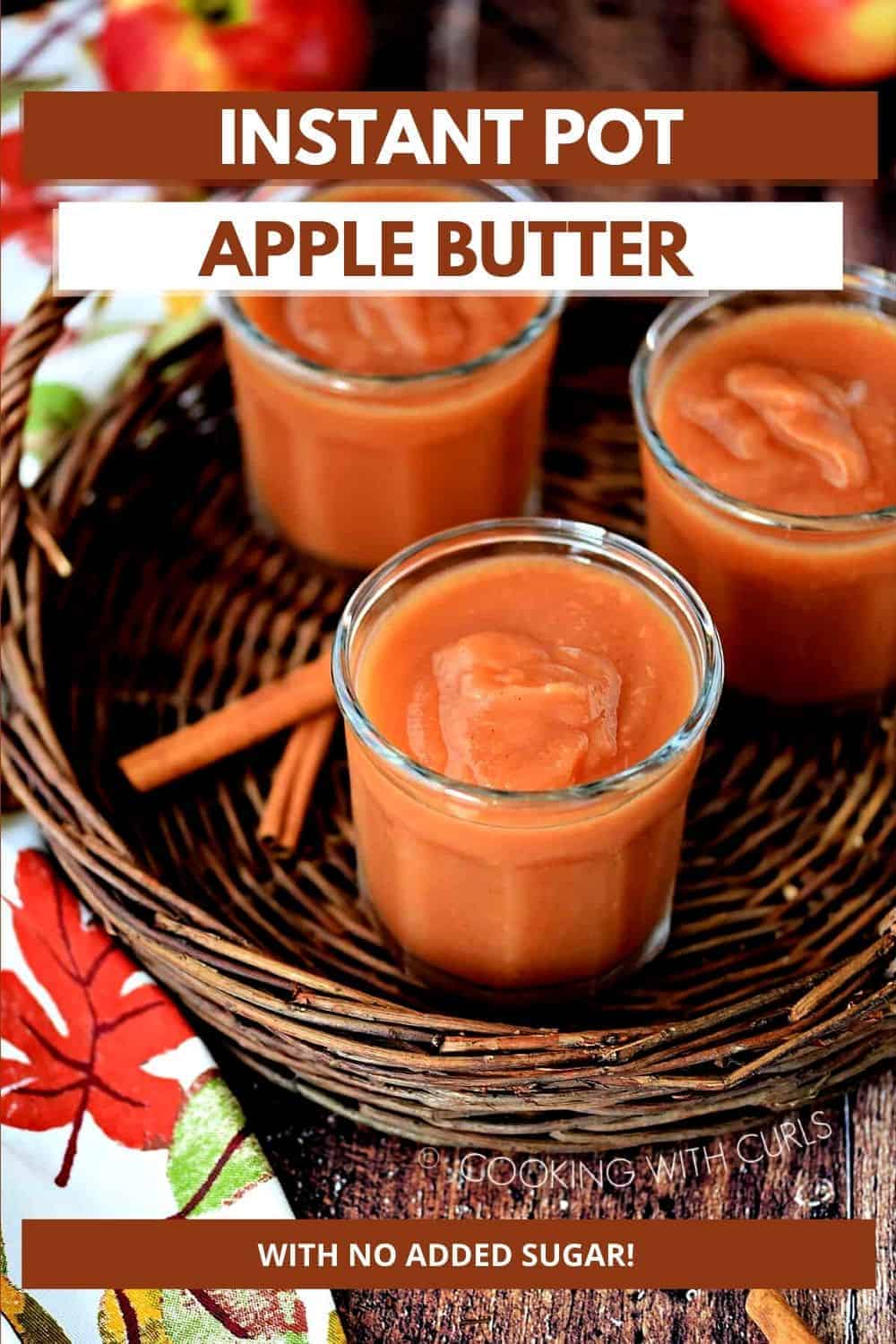 Three jars filled with apple butter on a wicker tray with cinnamon sticks, a fall napkin and apples in the background with title graphic across the top.