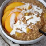 a close up of a bowl filled with steel cut oats topped with sliced peaches and drizzled with cream. title graphic across the top of image.