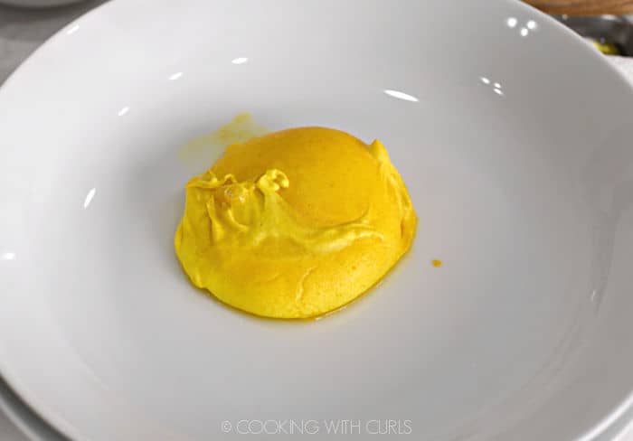 a turmeric poached egg in a white bowl. 