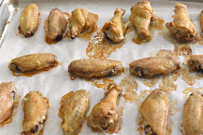 crispy baked chicken wings on a parchment lined baking sheet. 