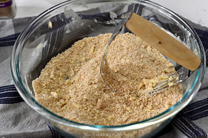 crumb topping mixed together in a glass bowl with a pastry blender. 