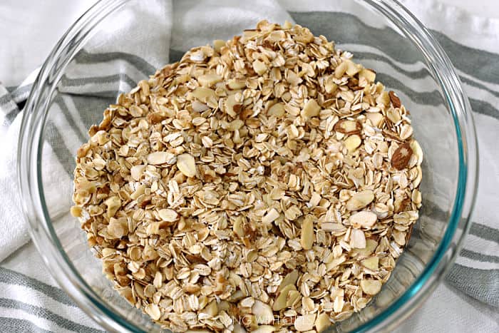 oats, nuts and flax seed mixed together in a large glass bowl. 