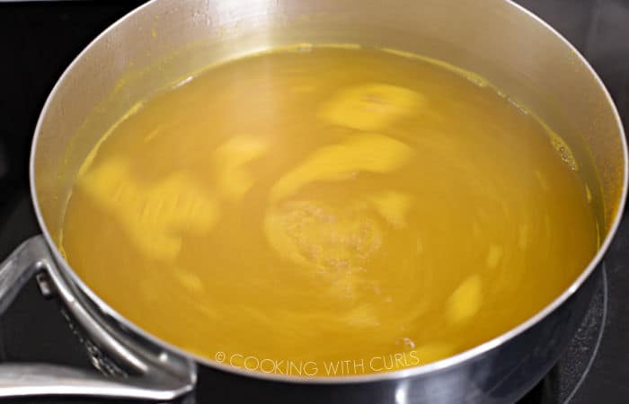 water mixed with vinegar and turmeric simmering in a saucepan. 
