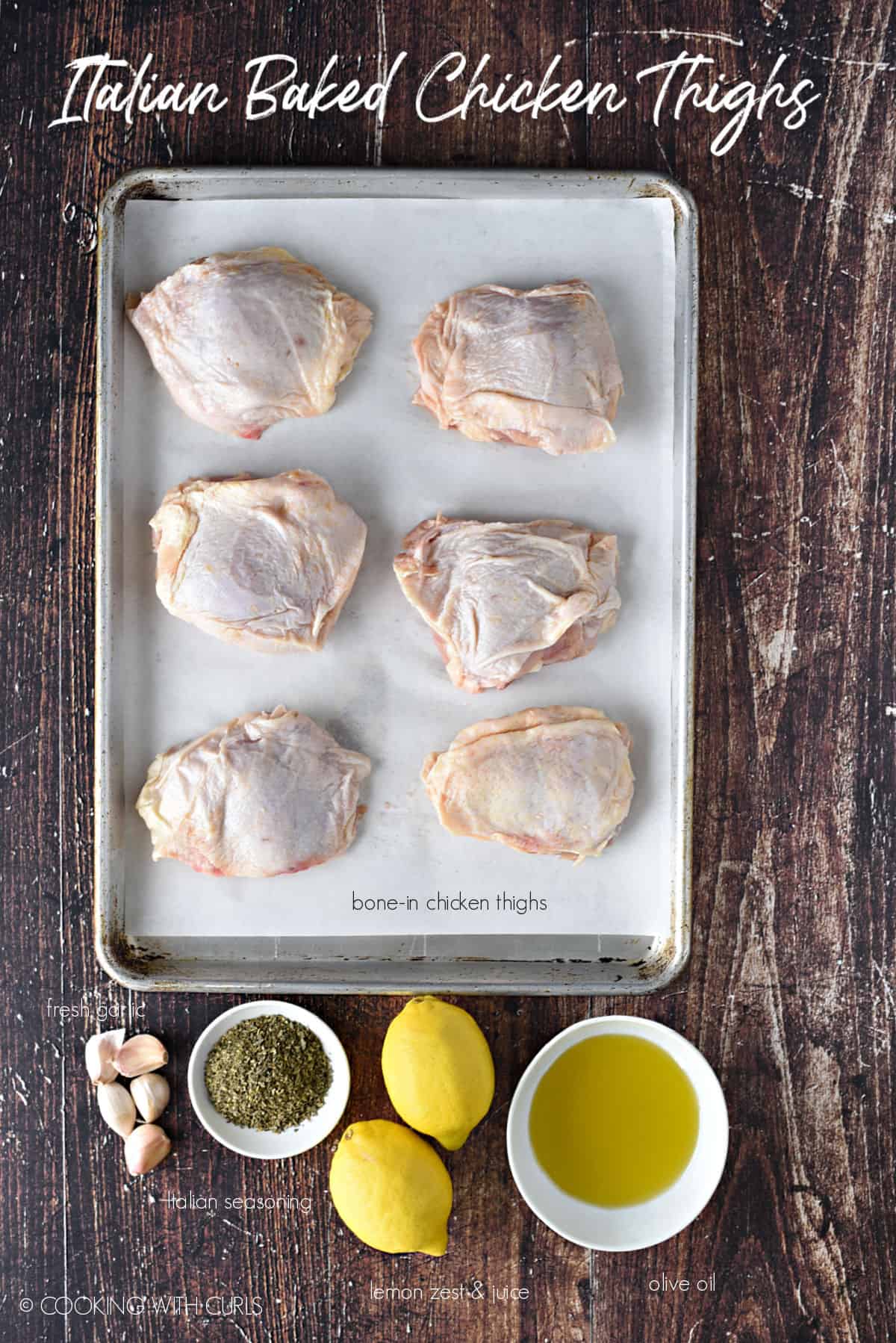 Ingredients to make Italian Baked Chicken Thighs; bone-in chicken thighs, garlic, Italian seasoning, lemons and olive oil. 