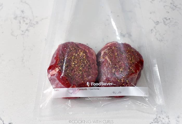 two seasoned tenderloin filets in a vacuum seal bag. 