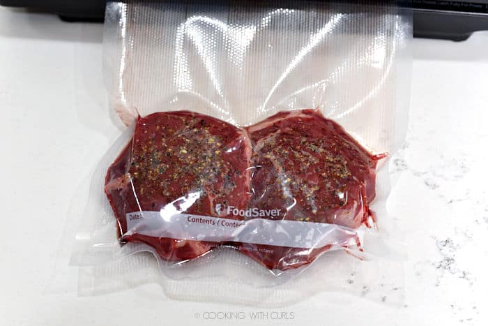 two vacuum sealed, seasoned filets with all of the air removed from the bag. 