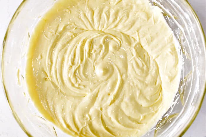 Eggs mixed into the cream cheese mixture in the glass bowl. 