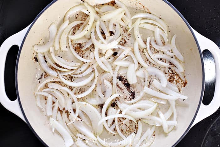 Sliced onions with olive oil in a skillet. 