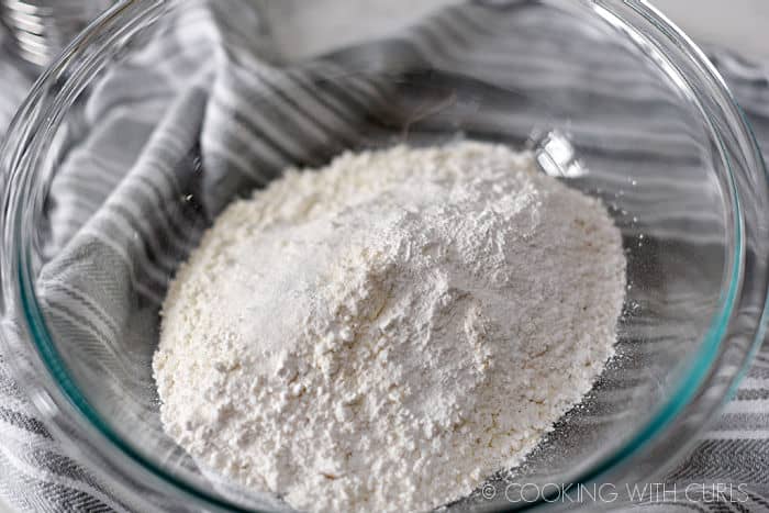 flour, salt, sugar, and baking powder in a clear glass bowl.