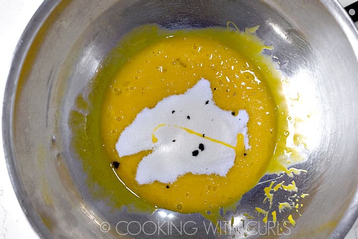 Beaten egg yolks, sugar and vanilla bean paste in a stainless steel bowl. 