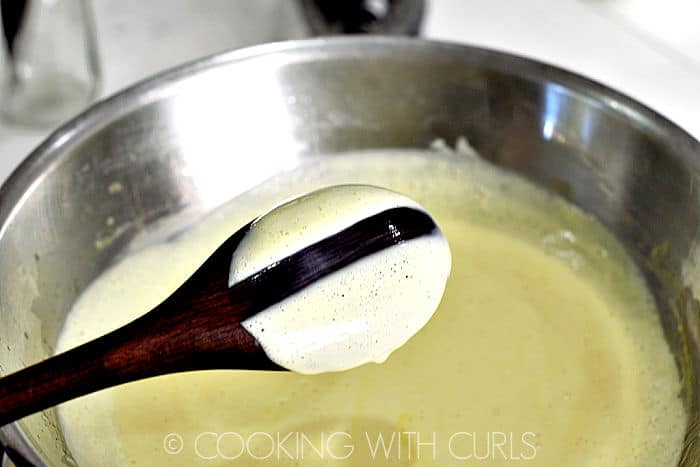 Cooked Creme Brulle on the back of a wooden spoon with a line drawn through it. 